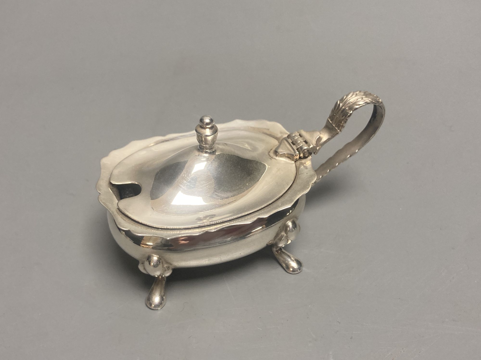 A late Victorian demi fluted silver mustard pot, London, 1894 and four other assorted later silver mustards.